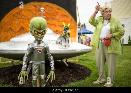 Eine Frau und ihr Hund besuchen Sie die Alien Statue und UFO-Skulptur für den Mars neue Jahre Feier 20. Juni in Mars, Pennsylvania 2015. Die Stadt ist Gastgeber für drei Tage von Stammzellen-bezogenen Aktivitäten. (Foto von Bill Ingalls über Planetpix) Stockfoto