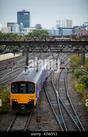 Northern British Rail Class 150 Sprinter Dieseltriebzüge Eisenbahnlinie von Ardwick führt zu Manchester Piccadilly Station, mit Sicht auf die City Skyline Stockfoto