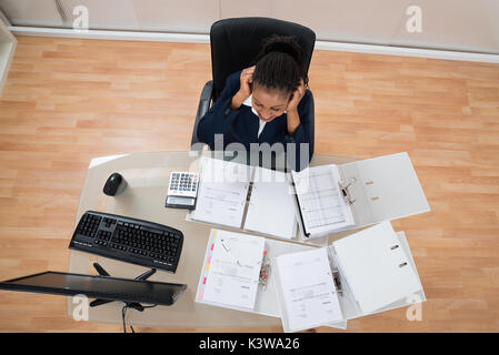 Überbelasten frustrierte Junge Geschäftsfrau im Büro Schreibtisch Stockfoto