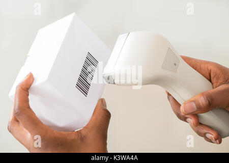 In der Nähe der Person Hand mit Barcode Scanner einen Barcode auf Produkt zu Scannen Stockfoto