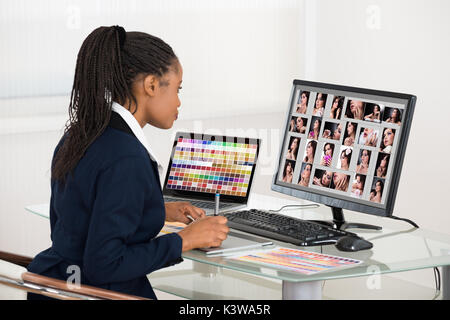 Junge afrikanische Designer Retuschieren von Fotos auf dem Computer Stockfoto