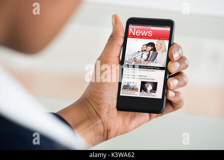 Nahaufnahme der Hand einer Frau, die das Lesen von Nachrichten auf dem Handy Stockfoto