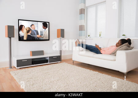 Junge afrikanische Frau Einschlafen beim Fernsehen zu Hause Stockfoto