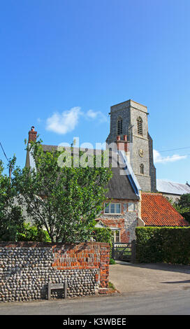 Ein Blick auf die traditionellen strohgedeckten Norfolk Cottage mit Pfarrkirche in Trunch, Norfolk, England, Vereinigtes Königreich. Stockfoto