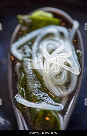 Nahaufnahme der Miso-suppe mit Seetang, Nudeln, Algen und Tofu auf dem Löffel Stockfoto