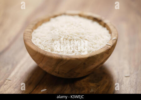 Trockene Basmati-reis in Holz Schüssel auf dem Tisch Stockfoto