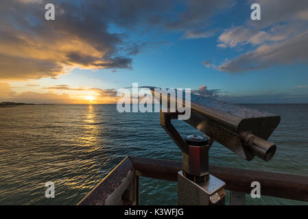 Teleskop mit Wassertropfen am Aussichtspunkt auf dem Pier von Heiligenhafen vor Sonnenuntergang über der Ostsee, Schleswig-Holstein, Deutschland Stockfoto