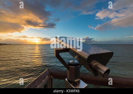 Teleskop mit Wassertropfen am Aussichtspunkt auf dem Pier von Heiligenhafen vor Sonnenuntergang über der Ostsee, Schleswig-Holstein, Deutschland Stockfoto