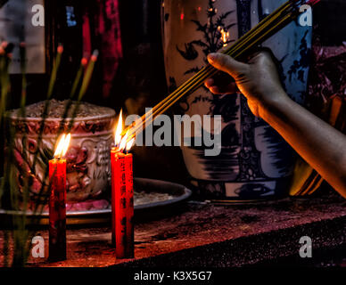 Kerzen brennen als Opfergabe in einem buddhistischen Tempel, Hanoi, Vietnam. Stockfoto