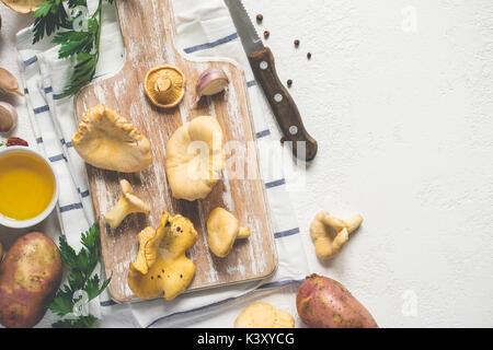 Weißer Hintergrund Kochen mit wilden Pfifferlinge auf einem Schneidebrett, Gewürze und Messer. Stockfoto