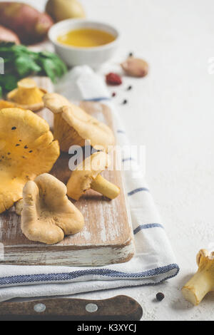 Raw Pfifferlinge auf einem Schneidebrett closeup auf weißen Hintergrund. Stockfoto