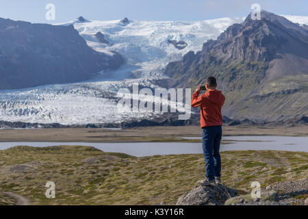 Touristische Bilder mit seinem Smartphone vor einem Gletscher in Island. Stockfoto