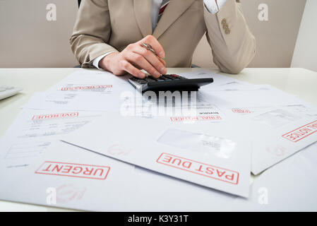 Nahaufnahme der Unternehmer rechnen mit Taschenrechner unbezahlte Rechnungen Stockfoto