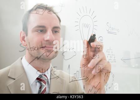 Geschäftsmann Schreiben Start Up-Plan auf Glas im Büro Stockfoto