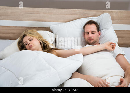 Paar mit weißen Bettdecke im Bett zu Hause schlafen Stockfoto