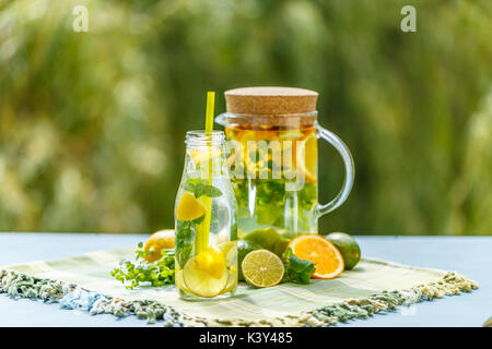 Detox Wasser gewürzt mit in Scheiben geschnittenen Zitrone, Orange, Limette und frischer Minze Blatt Stockfoto