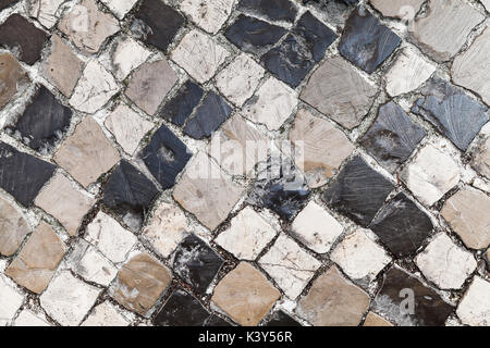 Old Stone Road Pavement, Hintergrund Textur. Calcada Straße mit Kopfsteinpflaster Mosaikboden aus Lissabon, Portugal Stockfoto