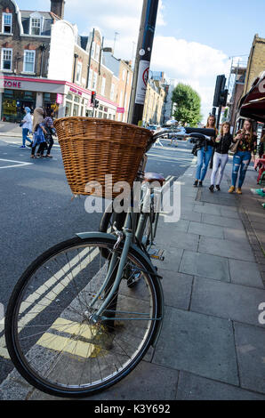 Ein Fahrrad links Aufgestützt gegen einen Laternenpfahl in Camden, London. Stockfoto