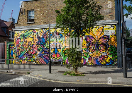 Bunte street art schmückt eine Wand an Buck Street in Camden Town, London. Stockfoto