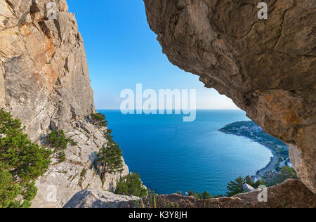 Die Aussicht aufs Meer und auf die Küste durch eine große Kluft in den Felsen. Die Berge der Krim Stockfoto