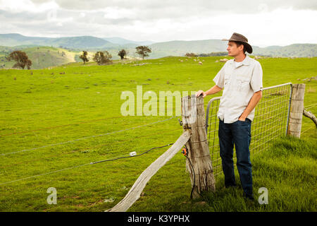 Aussie Bauer mit Blick auf ein Schaf Paddock Stockfoto