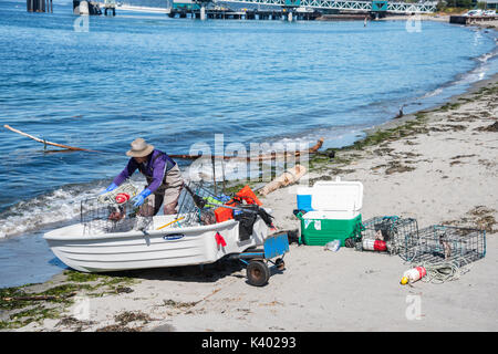 Fischer laden Boot mit Krabben Töpfen auf Strand, Edmonds, Washington Stockfoto