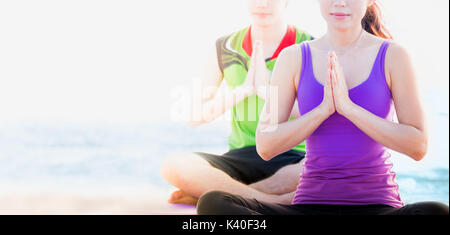 Close up Meisterin Yoga tun Namaste mit Student an Strand und blaues Meer darstellen, Mock up banner Platz für Ihren Text. Stockfoto