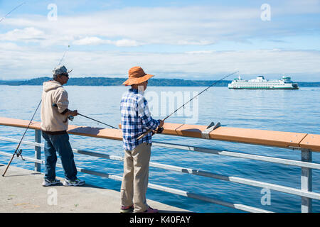 Mann und Frau Angeln am Pier mit Washington State Ferry im Hintergrund Stockfoto