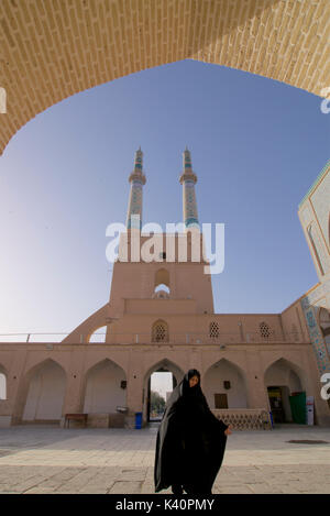 Iranische muslimische Frau im schwarzen Tschador, an Jameh Masjid. Freitag Moschee, Yazd, Iran Stockfoto