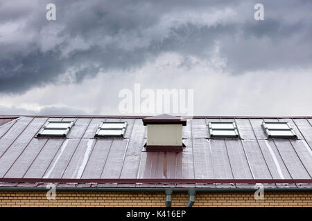 Neue Metall Dach mit Oberlichtern und Regenrinnen nass nach dem Regen Stockfoto