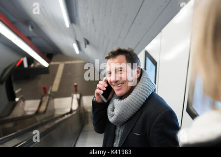 Ältere Mann mit Smartphone auf der Rolltreppe in u-Bahn Stockfoto