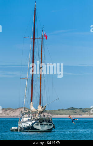 Ein junger Mann Schaukeln aus einer Linie auf einer Yacht Toloa genannt, in der Nähe von instow Beach in North Devon vertäut. Stockfoto