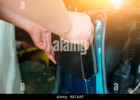 Closeup Instandsetzung eines defekten blaues Auto in der Garage durch die Hände von machanic. Stockfoto