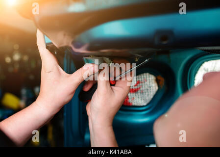 Closeup Instandsetzung eines defekten blaues Auto in der Garage durch die Hände von machanic. Stockfoto