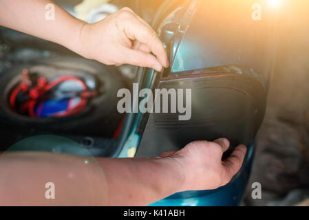 Closeup Instandsetzung eines defekten blaues Auto in der Garage durch die Hände von machanic. Stockfoto