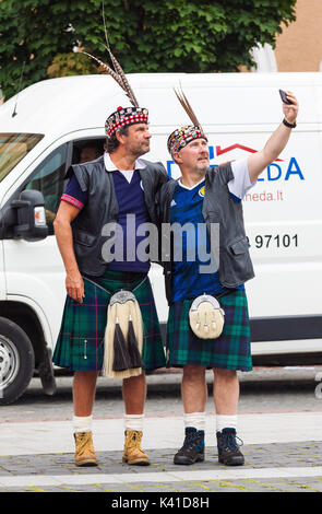 Zwei Männer mittleren Alters, Schottland Fußball-Fans in Nationale Kleidung eine selfie auf der Straße in Vilnius, Stockfoto