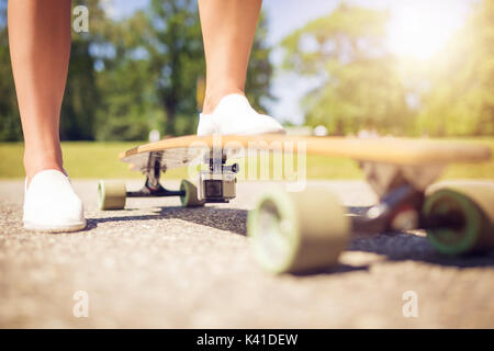 Ein Foto von Longboard mit Action Kamera installiert. Da ist jemand auf Sie. Stockfoto