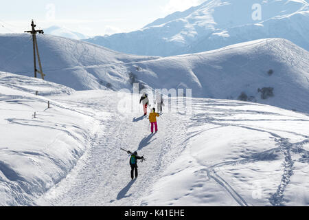 Skifahrer und Snowboarder auf Schnee Straße bei Sun winter Morgen. Kaukasus, Georgien, Region Gudauri. Stockfoto