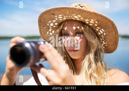 Ein Foto der jungen, schönen Frau auf ein Bild konzentrieren. Stockfoto