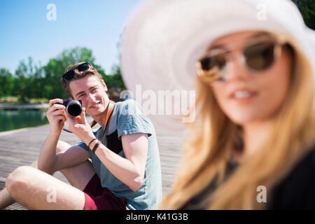 Ein Foto der junge Mann sitzt auf dem Steg und ein Foto der schönen Frau. Stockfoto