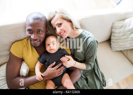 Interracial junge Familie mit Baby Söhnlein zu Hause. Stockfoto