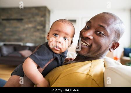 Jungen afroamerikanischen Vater, sein kleiner Sohn in den Armen zu halten Stockfoto