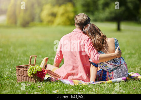 Ein Foto des jungen Paares bei einem Picknick im Park. Sie kuscheln. Stockfoto