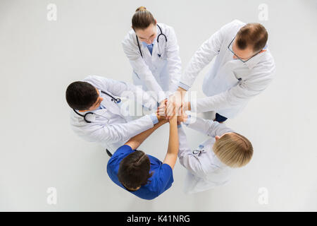 Gruppe von Ärzten mit Hände zusammen am Krankenhaus Stockfoto