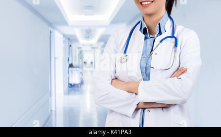 Lächelnd weibliche Arzt mit einem Ordner in Uniform am Krankenhaus. Stockfoto