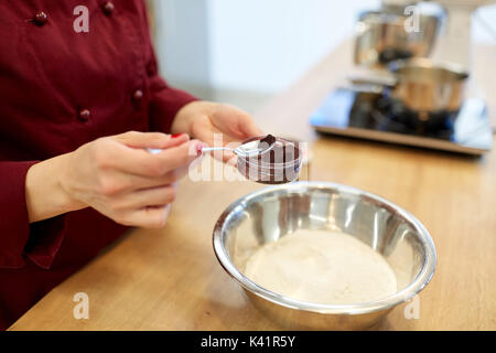 Koch Hände hinzufügen Essen Farbe in Schüssel mit Mehl Stockfoto