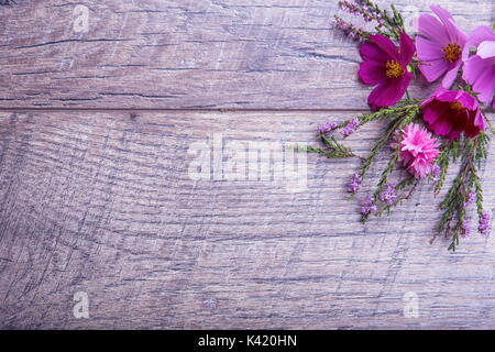 Ein Bouquet von rosa und lila Blumen cosmea oder Cosmos mit Band auf rustikalen hölzernen Brettern. Kopieren Sie Platz. Mutter, Valentines, Frauen, Hochzeit Konzept Stockfoto
