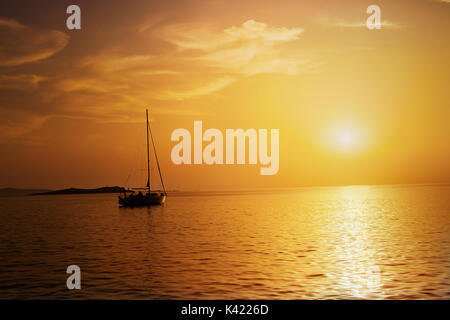 Segelboot aufs Meer bei Sonnenuntergang. Stockfoto
