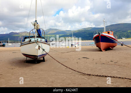 Tywyn, Wales, UK. August 05, 2017. Boote und Yachten Strand bei Ebbe im Hafen mit der Eisenbahnbrücke und Cader Idris Berge. Stockfoto