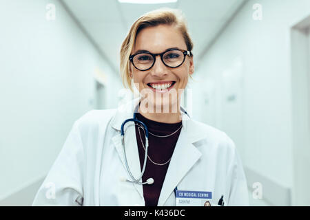 Porträt der glückliche junge Ärztin im Krankenhaus Flur. Kaukasische Frau arbeiten im Healthcare Center. Stockfoto